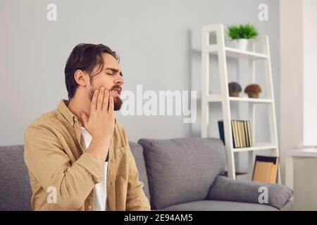 Uomo che soffre di nervo dentifricio infiammato e che tocca la guancia con dolore Foto Stock