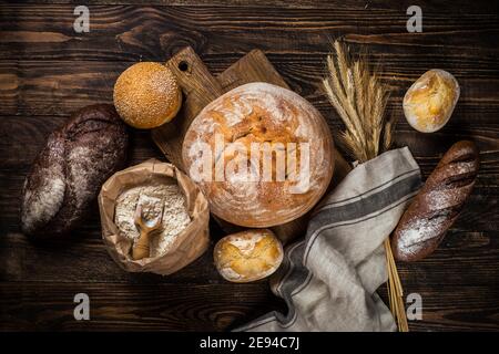 Pane fresco e panini a tavola rustica in legno. Foto Stock