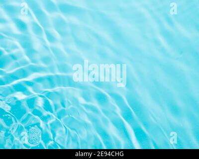 Ondulazione acqua texture su sfondo blu piscina. Ombra di acqua sulla luce solare. Mockup per prodotti, spa o viaggi di background. Marmo blu acqua superficie come sfondo carta da parati Foto Stock