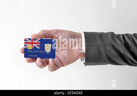 Carta di credito bancaria di plastica con bandiera di Anguilla holding uomo in un abito elegante Foto Stock