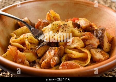 Tortellini al formaggio con funghi in piatto su stufatura naturale Foto Stock