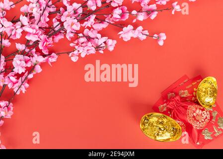 Sakura Blossom, busta rossa e lingotto d'oro su sfondo rosso con Copy Space Foto Stock