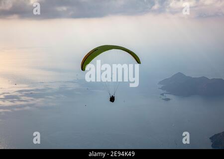 Parapendio nel cielo. Parapendio tandem che sorvola il mare con le montagne al tramonto. Veduta aerea del parapendio e della Laguna Blu a Oludeniz, Babadag Foto Stock