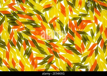 Pasta di penne tricolore. Pomodoro, spinaci e pasta di grano, illuminazione posteriore Foto Stock