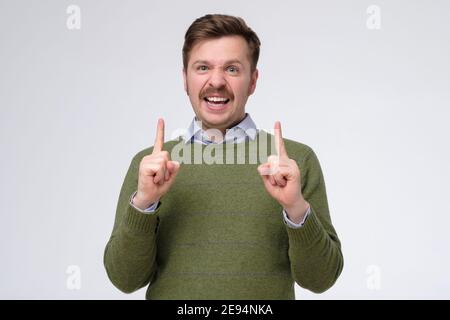 Divertente uomo caucasico con baffi che puntano su avere idea. Scatto in studio Foto Stock