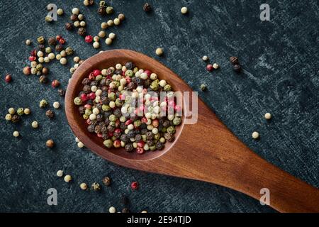 Misto di peppercorn in un cucchiaio di legno, vista dall'alto, primo piano Foto Stock