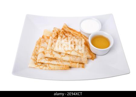 Colazione a base di pancake con panna acida e miele. È isolato su uno sfondo bianco. Foto Stock