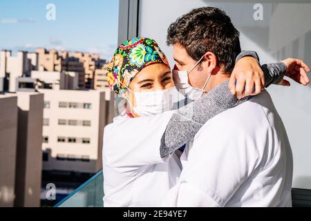 Due operatori sanitari si abbracciano e si conforgono reciprocamente nel momenti difficili di covid Foto Stock