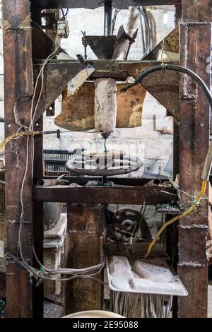 Macchine rustiche per la fusione della plastica e l'iniezione del liquido in getti o stampi. L'immagine è ripresa in un negozio rustico di una Cuba autonoma Foto Stock