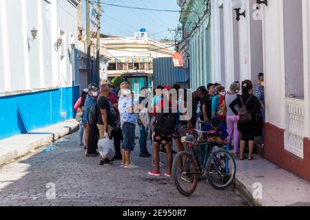 La gente cubana si sta schierando per comprare il pane a El rapido, che si trova nel centro della città. È il tempo del Covid-19 a Santa Clara, Cuba Foto Stock