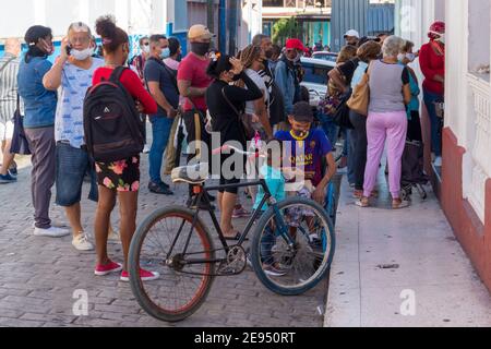 La gente cubana si sta schierando per comprare il pane a El rapido, che si trova nel centro della città. È il tempo del Covid-19 a Santa Clara, Cuba Foto Stock