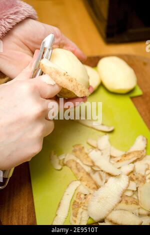 Donna che peeling patate primo piano Foto Stock