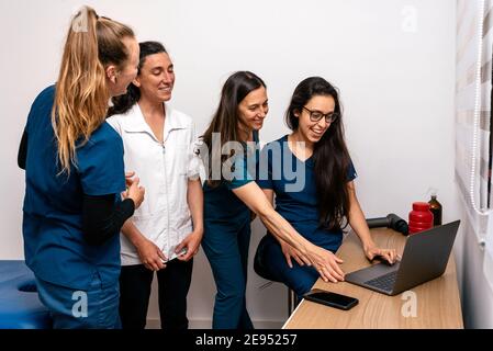 Foto d'inventario del team di lavoro unito di donne felici che lavorano in clinica di fisioterapia. Foto Stock