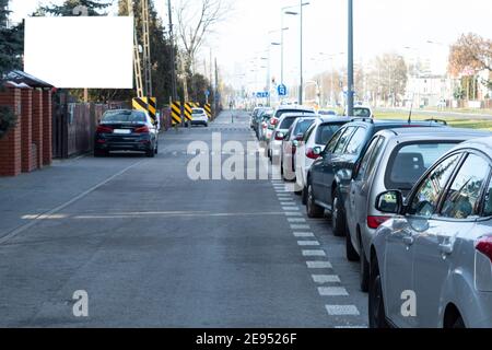 Una fredda mattina d'autunno su una strada cittadina e le auto parcheggiate di fila. Le auto sono parcheggiate nei sobborghi Foto Stock