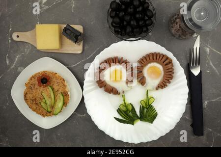 Salsiccia a forma di fiore e uova strapazzate per una colazione romantica. Una colazione originale e divertente per una persona cara. Colazione di San Valentino Foto Stock