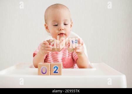 Bambina che gioca con cubetti di legno con numeri luminosi 2022 Foto Stock