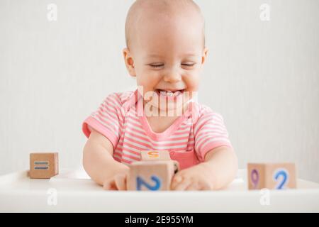 Bambina che gioca con cubetti di legno con numeri luminosi Foto Stock