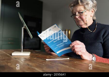 OXFORD, UK - Febbraio 2020: Una donna legge il kit di test per la casa Covid-19 del governo Foto Stock