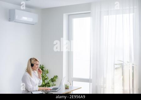 Felice giovane imprenditrice lavorando in ufficio con aria condizionata Foto Stock