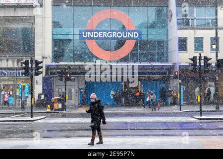 Pedestians fuori dalla stazione della metropolitana di Brixton durante la neve pesante, Brixton, Londra, 24 gennaio 2021 Foto Stock