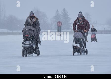 Ottawa, Canada. 2 Febbraio 2021. Le madri che pattinano mentre spingono i passeggini del bambino sul canale di Rideau Skgateway nella capitale canadese Foto Stock