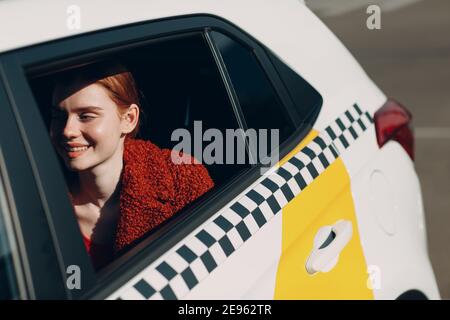 La giovane donna si siede in taxi auto sul sedile posteriore. Foto Stock