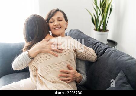 Supporto e concetto di amore. Due donne diverse generazioni stanno abbracciando, una madre anziana sta abbracciando una figlia adulta. Legami familiari Foto Stock