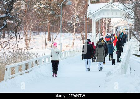 Seurasaari, Helsinki. Finlandia 31 gennaio 2021. Le persone attraversano il ponte. Concetto di stile di vita sano. A piedi al mare. Foto di alta qualità Foto Stock