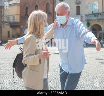 Amore nel tempo di riunione di coppia senior del coronavirus all'aperto Foto Stock