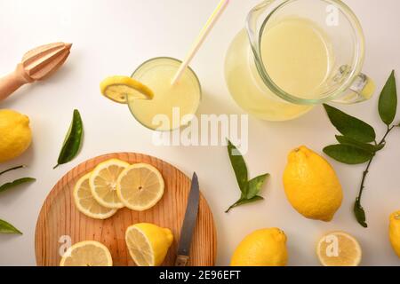 Succo di limone appena preparato con utensili sulla panca bianca della cucina. Vista dall'alto. Composizione orizzontale. Foto Stock