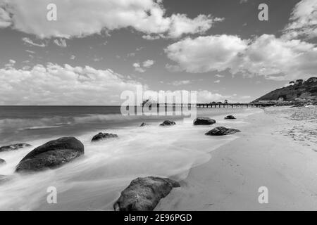 Vista in bianco e nero della spiaggia del Malibu Pier con movimento Sfocatura surf nella California meridionale Foto Stock