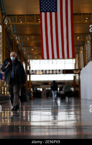 (210203) -- ARLINGTON, 3 febbraio 2021 (Xinhua) -- i viaggiatori che indossano le maschere sono visti all'aeroporto nazionale Ronald Reagan Washington di Arlington, Virginia, gli Stati Uniti, 2 febbraio 2021. All'inizio di martedì, gli americani sono tenuti a indossare maschere facciali mentre viaggiano sui trasporti pubblici nazionali come parte di una strategia nazionale per limitare la diffusione del COVID-19. La regola di indossare la maschera che andrà in vigore alle 11:59 Lunedi (0459 GMT Martedì) fa il rifiuto di indossare una maschera una violazione della legge federale, imposto dalla Transportation Security Administration e altri autori federali, statali e locali Foto Stock