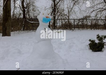 Nuova realtà, sulla protezione dalle infezioni, la vita nella covid epidemia con Snowman in una maschera medica Foto Stock