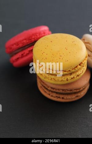 Macaron colorati isolati su sfondo nero Foto Stock