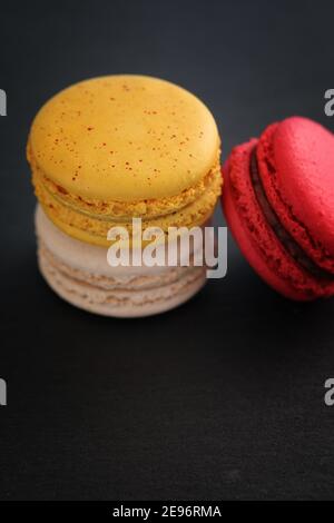 Macaron colorati isolati su sfondo nero Foto Stock