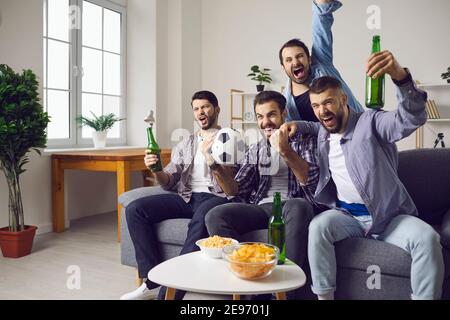 Gruppo di uomini eccitati amici tifosi di calcio sentirsi felici e. festeggiamo l'obiettivo delle squadre preferite Foto Stock