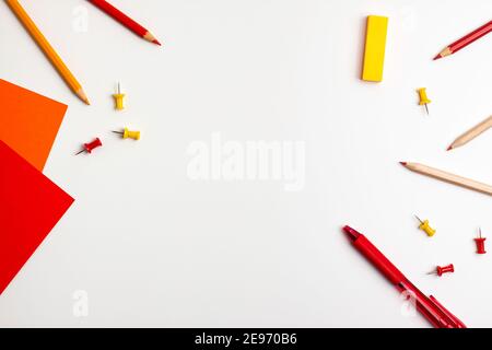 Penna rossa e gialla, nota adesiva, blocco note, pennarello, gomma, spille, matite di graffetta su sfondo bianco piatto Vista dall'alto Education torna a scuola Foto Stock