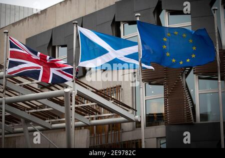 File foto del 29/1/2020 della bandiera dell'Unione, del salario e della bandiera dell'Unione europea che battono fuori dal Parlamento scozzese a Edimburgo. L’indipendenza avrebbe colpito l’economia scozzese più duramente della Brexit, e il ricongiungersi all’UE non farebbe molta differenza, ha affermato un gruppo di accademici. Il danno economico derivante dall'uscita da entrambi i sindacati sarebbe l'equivalente di una perdita di reddito compresa tra £2,000 e £2,800 a persona, secondo un'analisi del commercio condotta dalla London School of Economics (LSE). Data di emissione: Mercoledì 3 febbraio 2021. Foto Stock