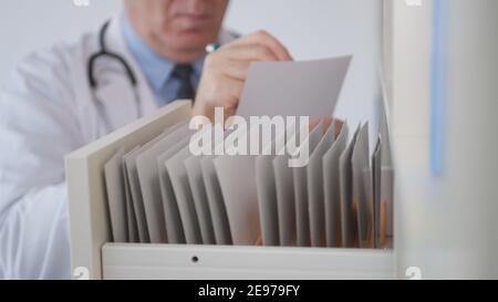 Immagine con un medico che cerca le cartelle cliniche nell'archivio ospedaliero. Foto Stock
