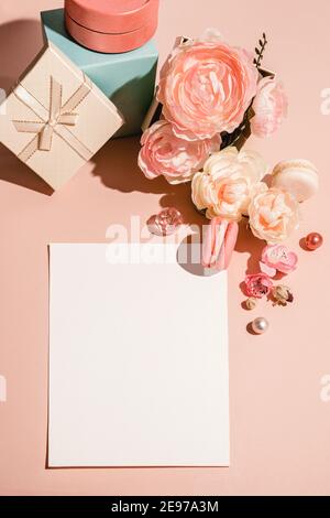 Sfondo astratto con fiori, scatole da regalo e un modello per le carte, inviti in colori pastello muti. Foto Stock