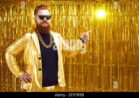 Divertente rman sorridente in costume hipster dorato che indica da parte dito Foto Stock