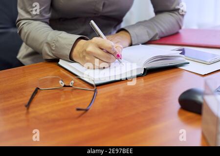 Concetto di business, closeup femminile mani scrittura in business notebook Foto Stock