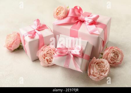 Scatole regalo e rose su sfondo bianco testurizzato, primo piano Foto Stock