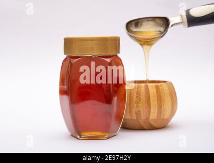Vaso di miele naturale riempito con cucchiaio sullo sfondo. Foto Stock