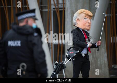 Edimburgo, Scozia, Regno Unito. 3 febbraio 2021. Nella foto: In vista di un dibattito e di un voto al Parlamento scozzese per decidere se il governo scozzese dovrebbe indagare sul finanziamento dei campi da golf scozzesi da parte di Donald Trump, gli attivisti ritrarranno un falso Trump che indossa una testa gigante, una cravatta rossa e porta un cartello con la scritta "Incolosimi!" Al di fuori del Parlamento scozzese. Inoltre trascinerà il suo sacchetto di golf che traboccola con le fatture del dollaro. Credit: Colin Fisher/Alamy Live News Foto Stock