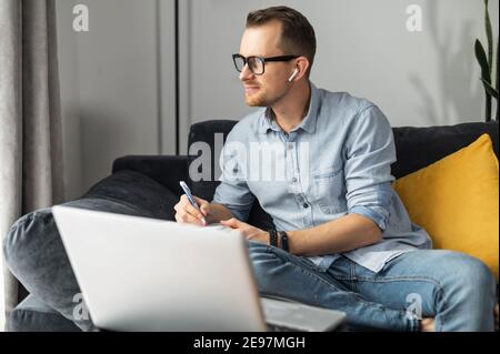 L'uomo d'affari intelligente perso in pensa a risolvere un problema aziendale complesso, lo sviluppo, l'ingegneria. Freelance che utilizza un notebook per lavorare da Foto Stock