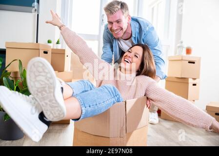 Marito e moglie si spostano in una nuova casa - giovane coppia appena spostato in un nuovo appartamento - persone e concetto di rilocazione. Foto Stock