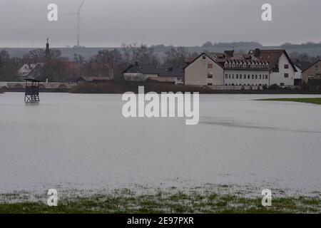 Eichen, Germania. 03 Feb 2021. L'acqua alluvione di Eichen, vicino a Nidderau, raggiunge le case. In Assia, numerosi fiumi hanno fatto esplodere le loro rive a causa dello scioglimento della neve e delle persistenti precipitazioni. Credit: Boris Roessler/dpa/Alamy Live News Foto Stock