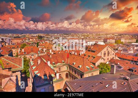 Cielo drammatico con nuvole rosse di tramonto sul paesaggio urbano dello skyline di Ginevra, franco-svizzero in Svizzera. Vista aerea della città vecchia con i suoi tetti e. Foto Stock