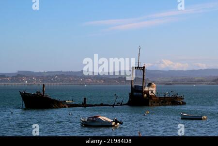 Sciarro relitto rugnante correre aground baia di Santander Cantabria Spagna con piccole barche da pesca e yacht a motore ormeggiati a boe sole mattina invernale Foto Stock